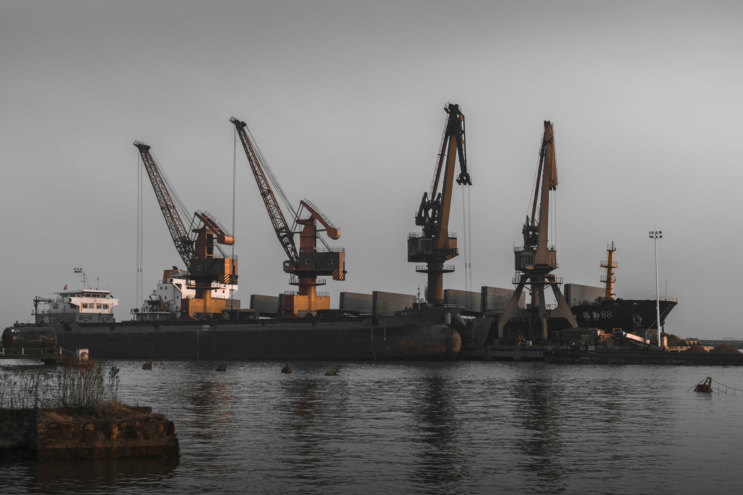 Ships and cranes at an industrial shipyard quay